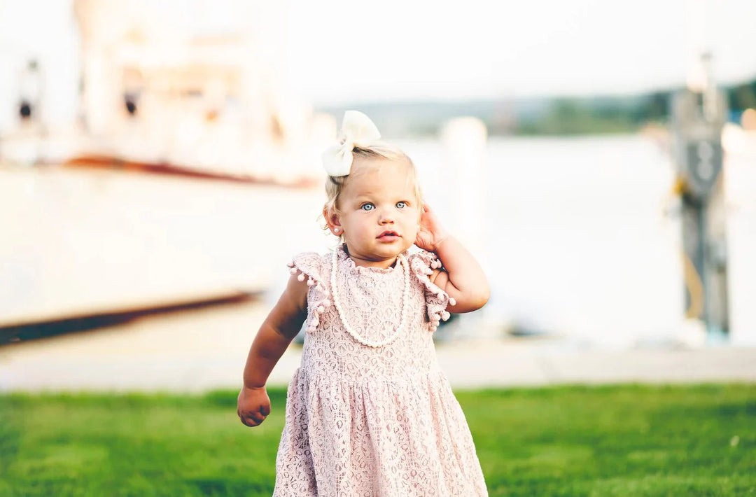 Baby girl wearing a pearl necklace and pearl earrings